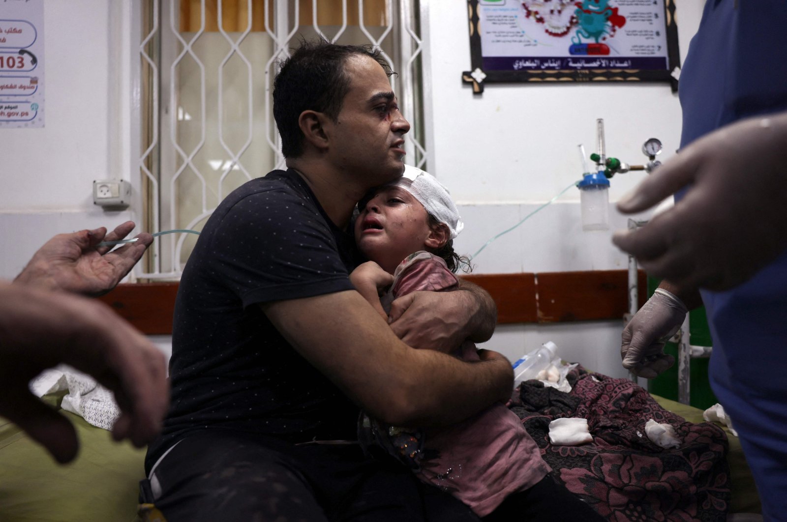 A Palestinian man cradles an injured child at the Najjar Hospital following an Israeli airstrike on a home in Rafah, in the southern Gaza Strip, Palestine, Oct. 30, 2023. (AFP Photo)