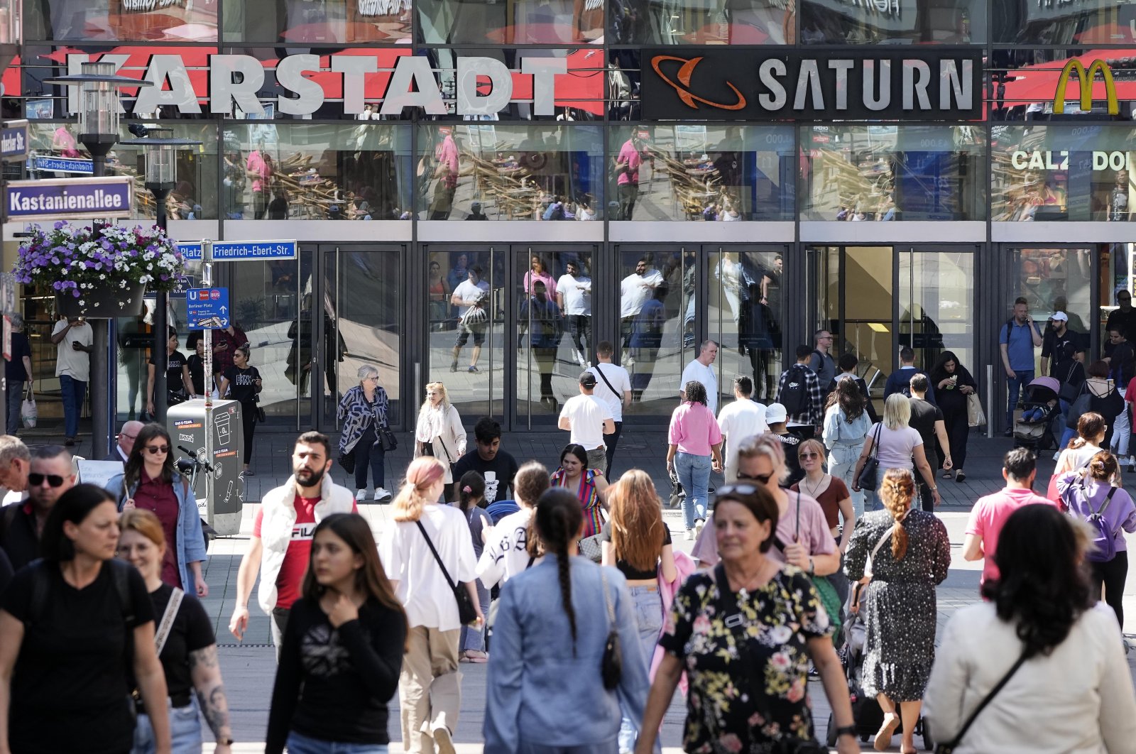 People walk on a shopping street in Essen, Germany, May 31, 2023. (AP Photo)