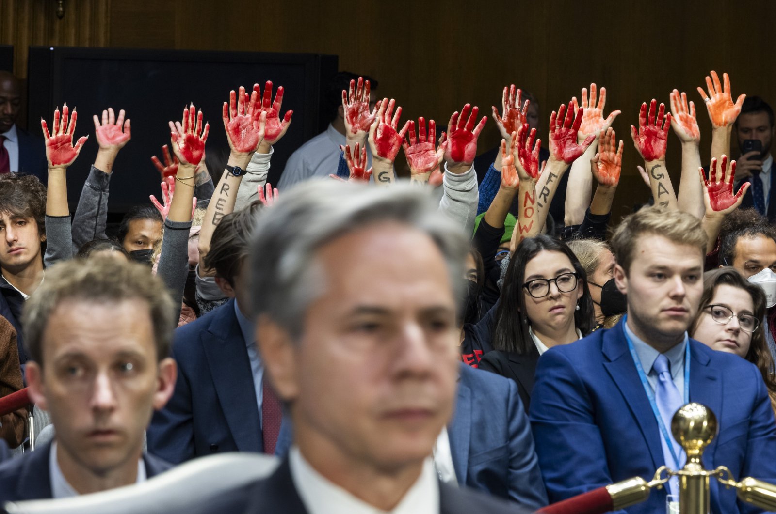 Protesters calling for a cease-fire in Gaza raise their hands covered in red as U.S. Secretary of State Antony Blinken (C) and Secretary of Defense Lloyd Austin (not pictured) testify at a Senate Appropriations Committee hearing to review their national security supplemental requests in the Dirksen Senate Office Building in Washington, D.C., Oct. 31, 2023. (EPA Photo)