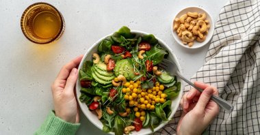 A vegan plant-based salad in a bowl with avocado, cashew, micro-greens, pok choi, chickpeas, tomato, lettuce, cucumber and sesame. (Getty Images Photo)