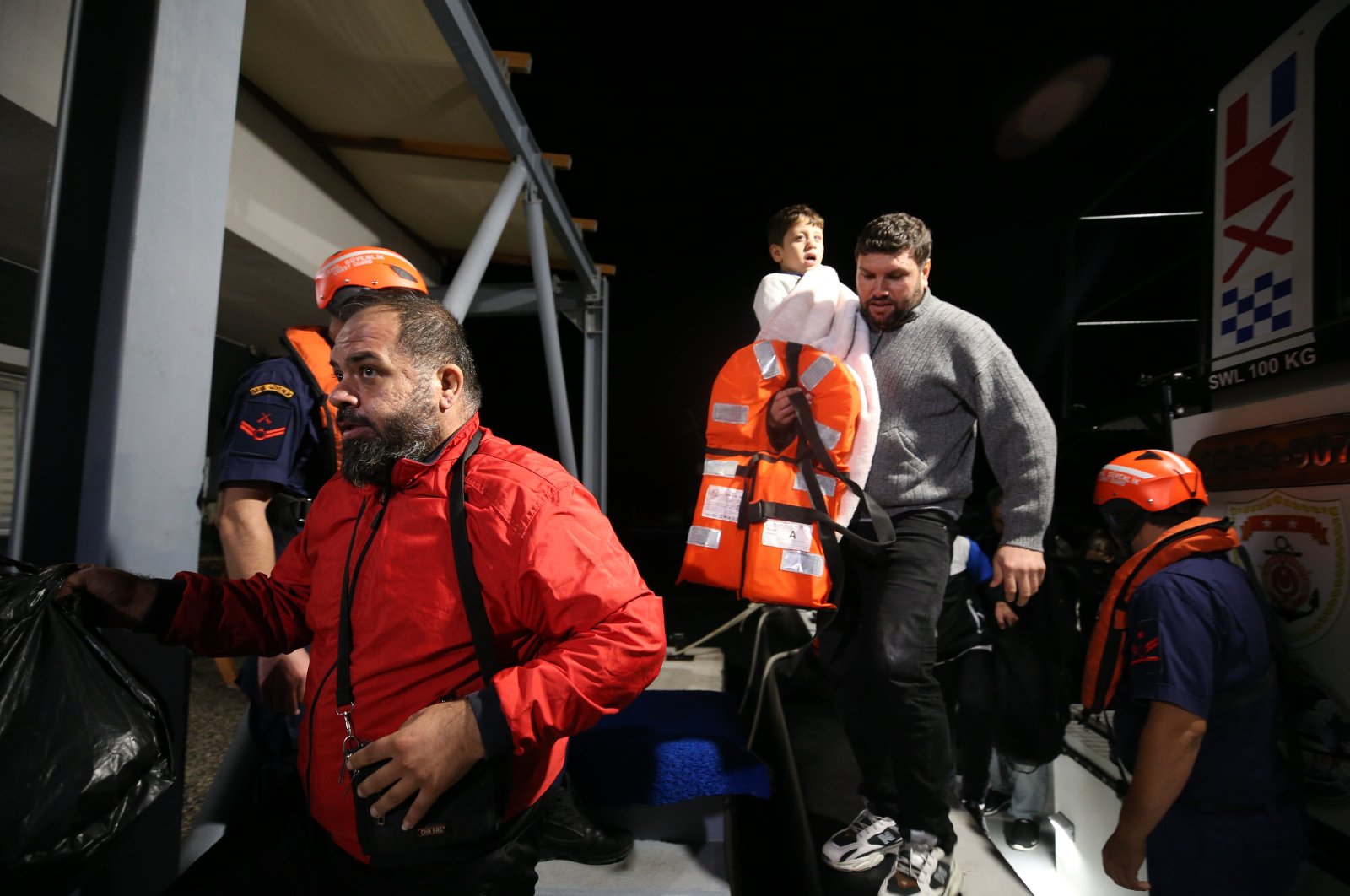 Irregular migrants disembark from the Coast Guard Command boat that saved them, Izmir, western Türkiye, Nov. 1, 2023. (AA Photo)