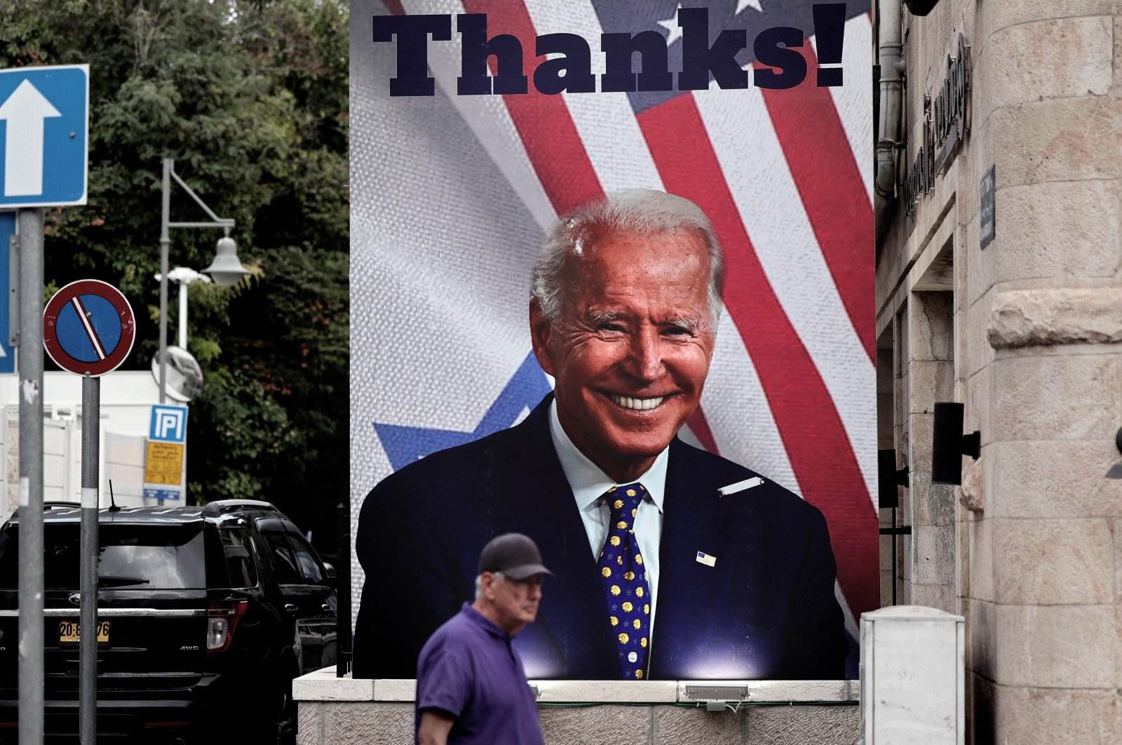 A man walks past a giant poster of U.S. President Joe Biden in a street of Jerusalem, Oct. 20, 2023. (AFP Photo)