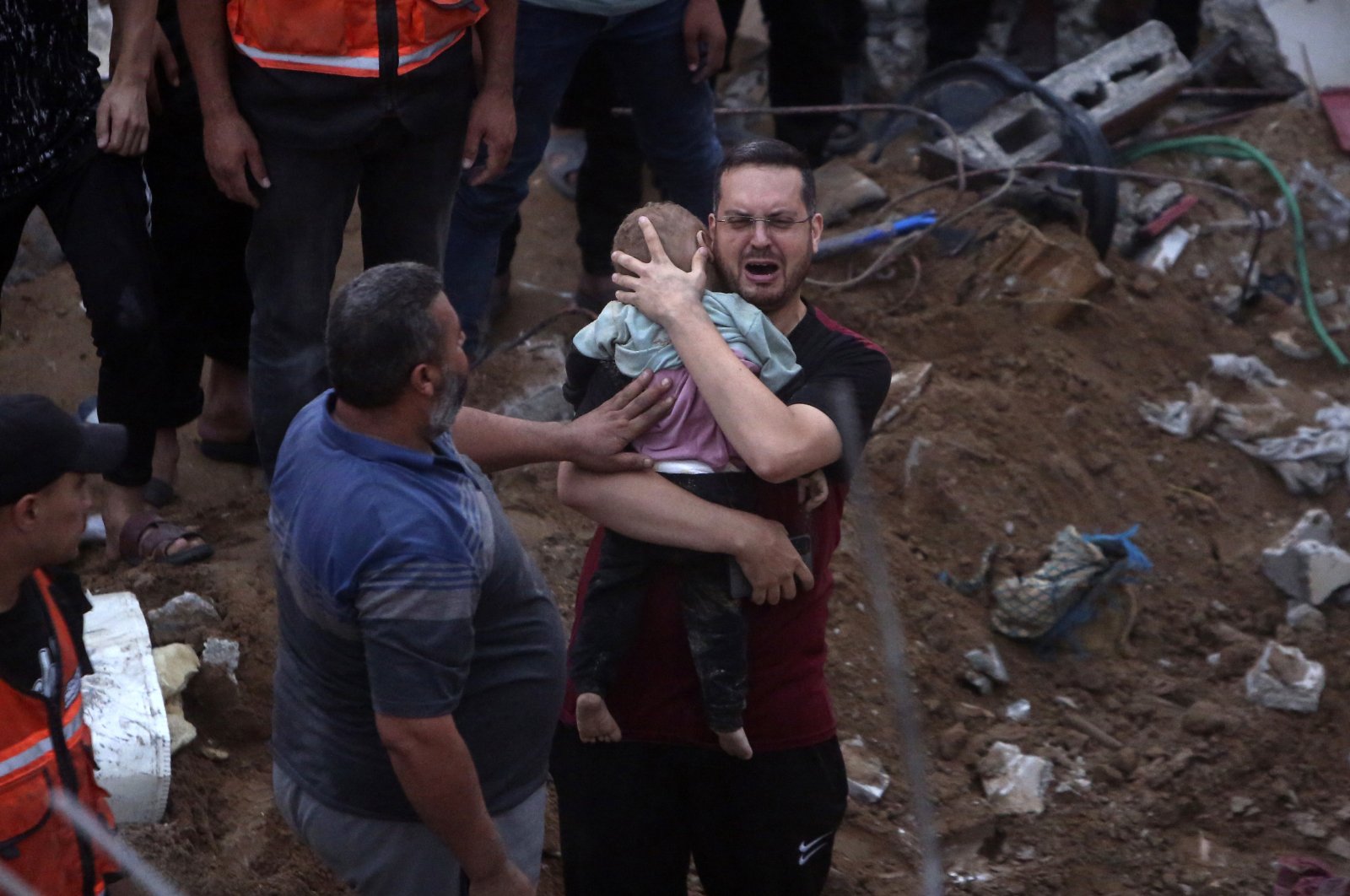 A Palestinian man cries while holding a dead child who was found under the rubble of a destroyed building following Israeli airstrikes in Nusseirat refugee camp, central Gaza Strip, Palestine, Oct. 31, 2023. (AP Photo)