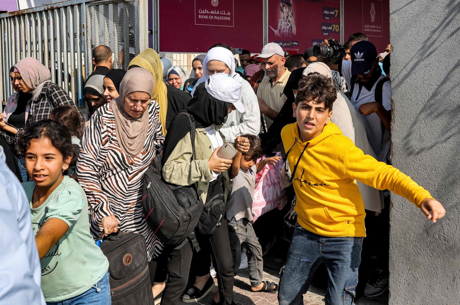 People walk through a gate to enter the Rafah border crossing to Egypt, southern Gaza Strip, Palestine, Nov. 1, 2023. (AFP Photo)