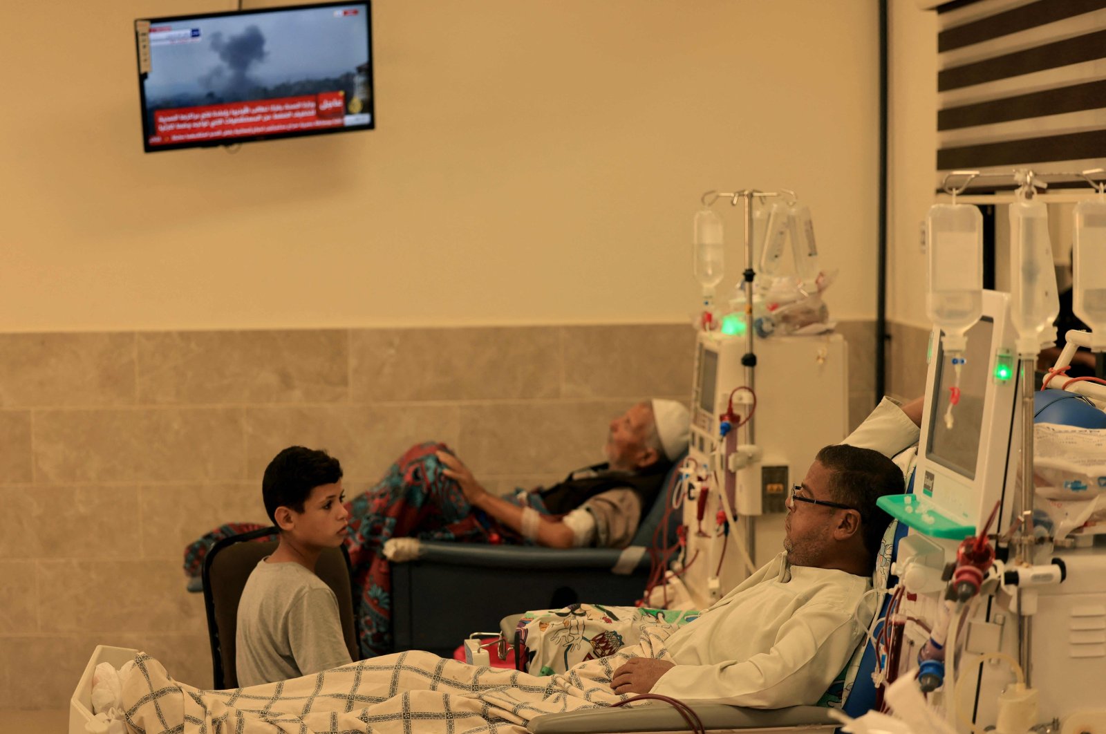 A patient watches the news on a television as he undergoes dialysis at a hospital in Khan Yunis in the southern Gaza Strip, Palestine, Oct. 24, 2023. (AFP Photo)