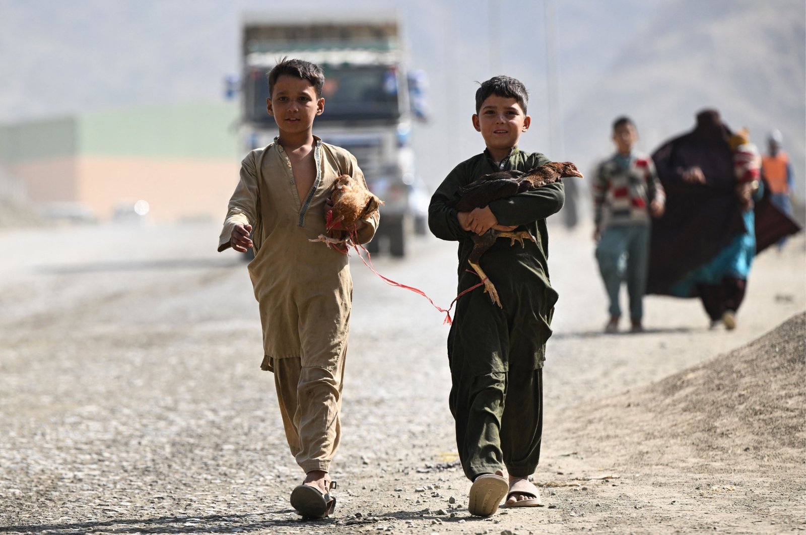 Afghan refugee boys carrying hens arrive to cross the Pakistan-Afghanistan Torkham border, Pakistan, Nov. 2, 2023. (AFP Photo)