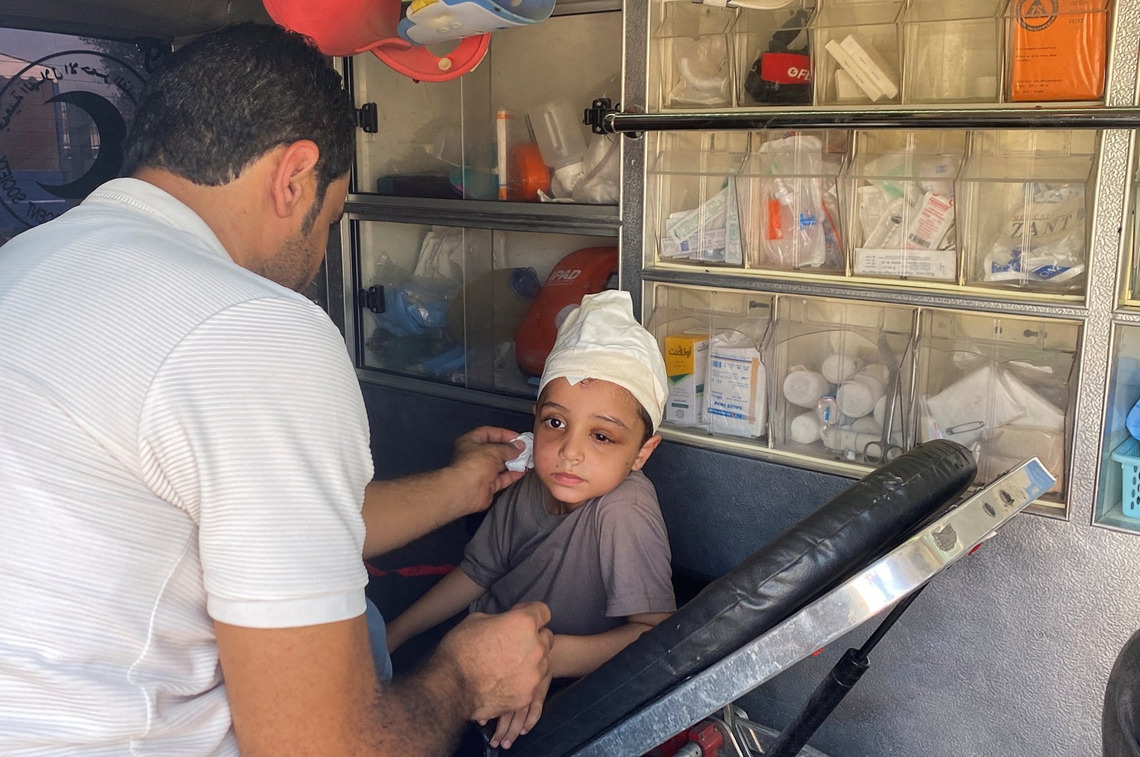 Palestinian boy Ameer Joma, who was injured in an Israeli strike, sits with his father in an ambulance as they wait to be transported for treatment in an Egyptian hospital, Rafah border crossing, southern Gaza Strip, Palestine, Nov. 1, 2023. (Reuters Photo)