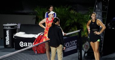 The umpire talks to the players after the rain starts again during a WTA Finals match between Belarus' Aryna Sabalenka and Kazakhstan's Elena Rybakina, Cancun, Mexico, Nov. 2, 2023. (Reuters Photo)