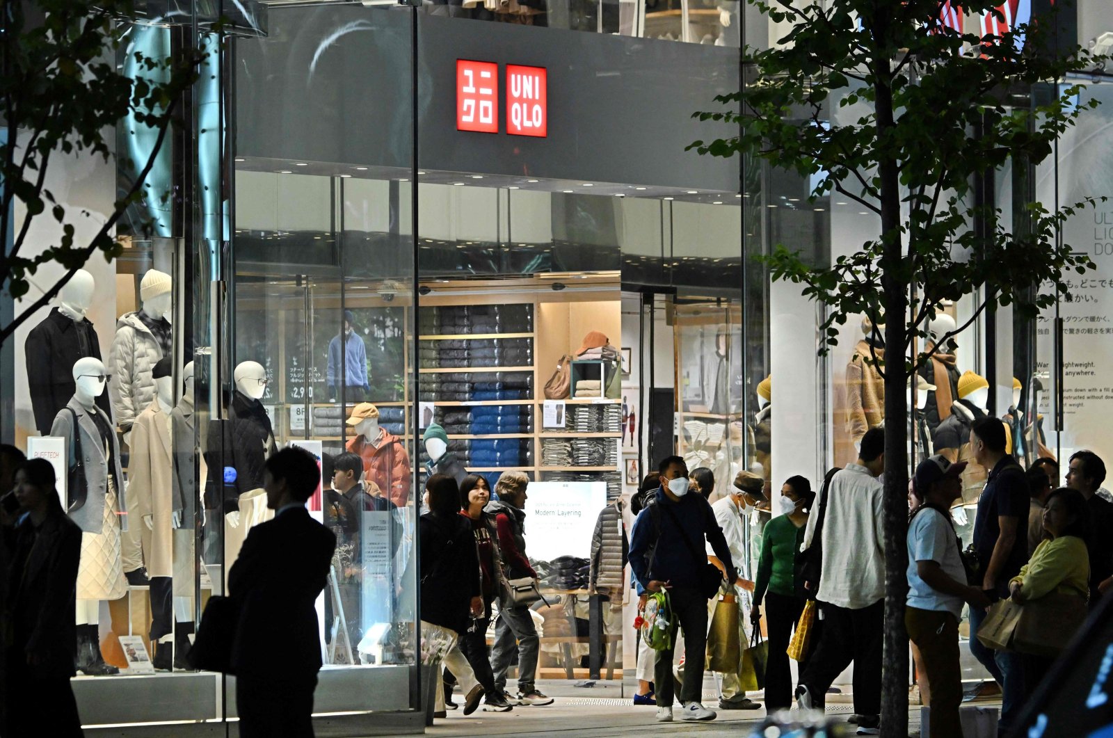 People gather outside a branch of the Fast Retailing clothing brand UNIQLO along a street in downtown Tokyo, Japan, Oct. 12, 2023. (AFP Photo)