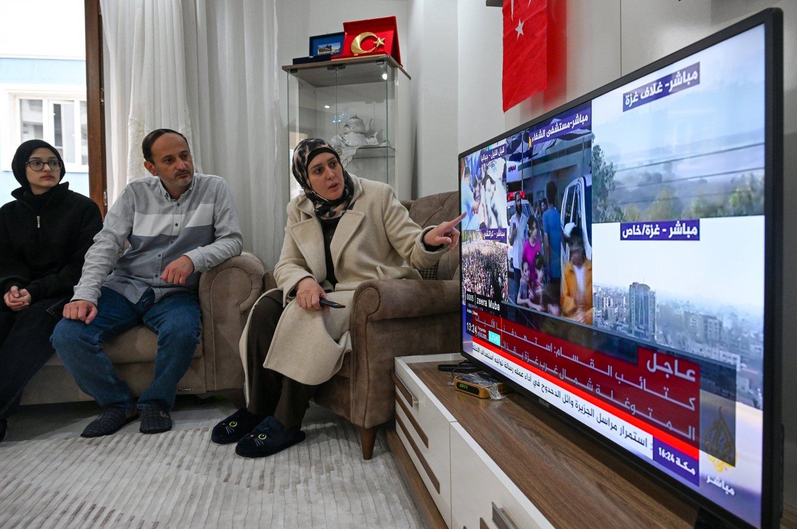 Palestinian academic Asmaa Younis (R) follows the developments in Gaza on television, Van province, Türkiye, Nov. 6, 2023. (AA Photo)