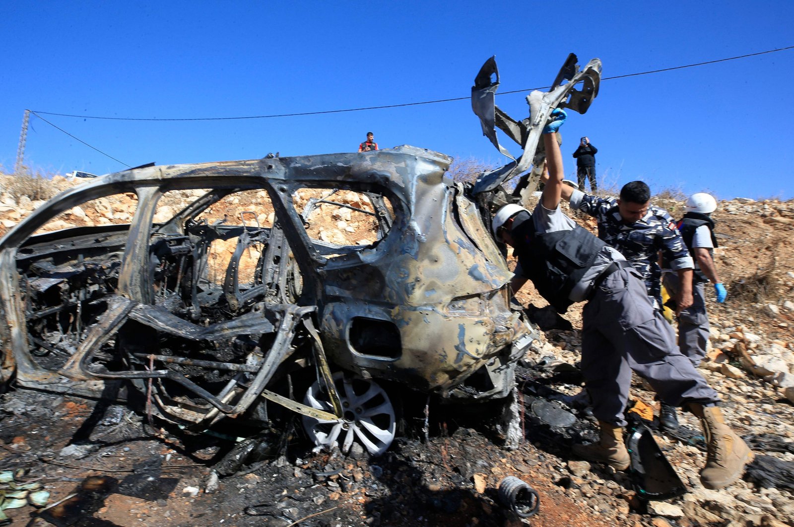 Rescuers from Hezbollah&#039;s Islamic Sanitary committee inspect the wreckage of a vehicle in which civilians were killed during an Israeli strike in southern Lebanon near the border with Israel, on Nov. 6, 2023. (AFP Photo)