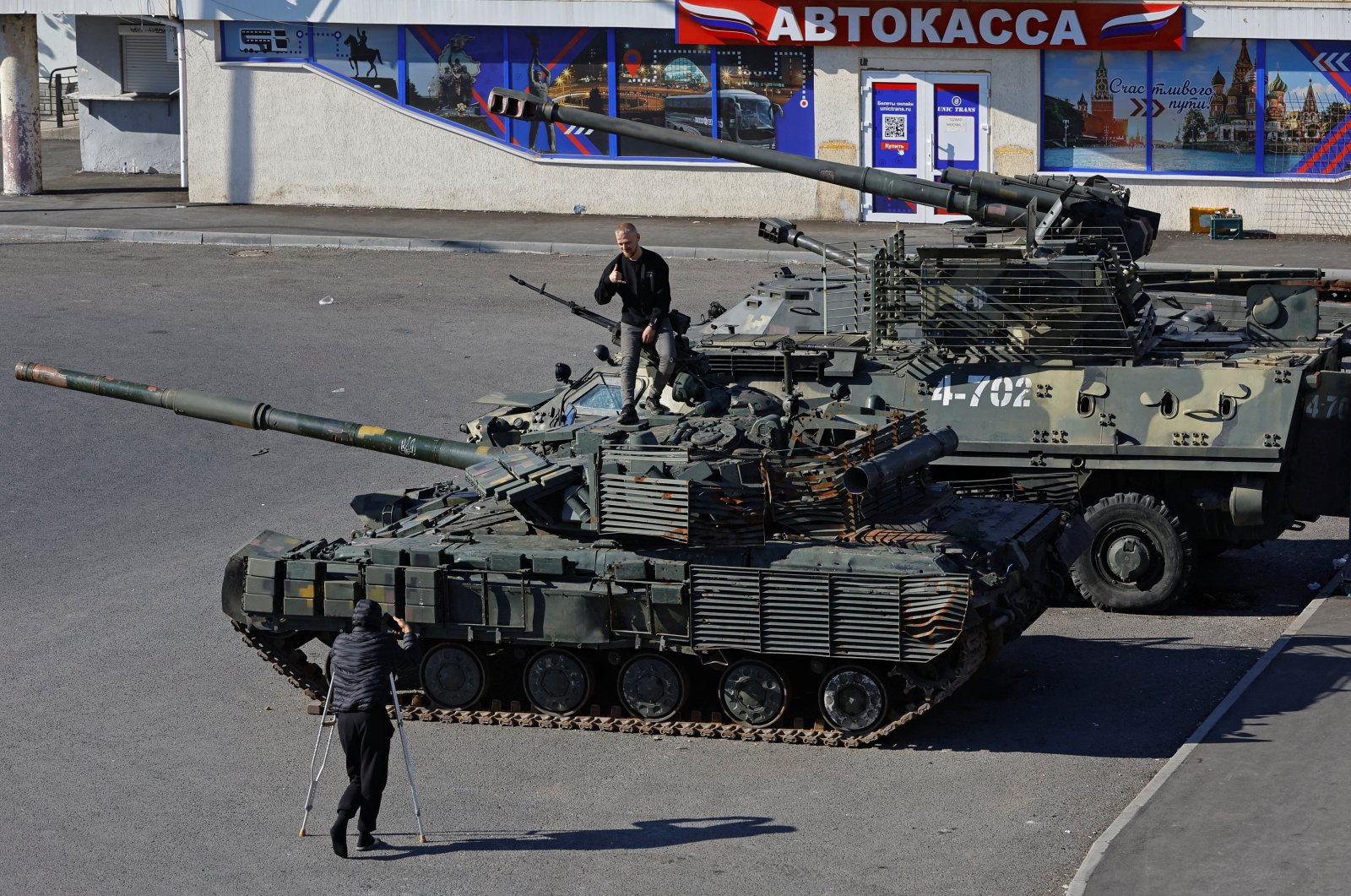 A man poses atop a tank at an exhibition of Ukrainian military equipment captured in the course of the Russia-Ukraine conflict, at the station square in Luhansk, Ukraine, Oct. 15, 2023. (Reuters File Photo)