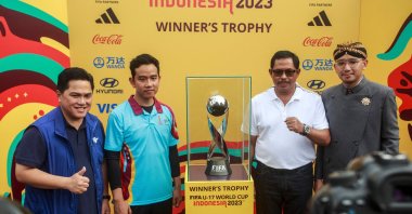 The Solo Mayor Gibran Rakabuming Raka (2nd L), a vice presidential candidate and Indonesian President Joko Widodo&#039;s son, and Indonesian Football Association&#039;s Chairperson Erick Thohir (L) pose next to the FIFA U-17 World Cup trophy during a promotional event for the upcoming youth football tournament, Solo, Indonesia, Nov. 5, 2023. (AFP Photo)