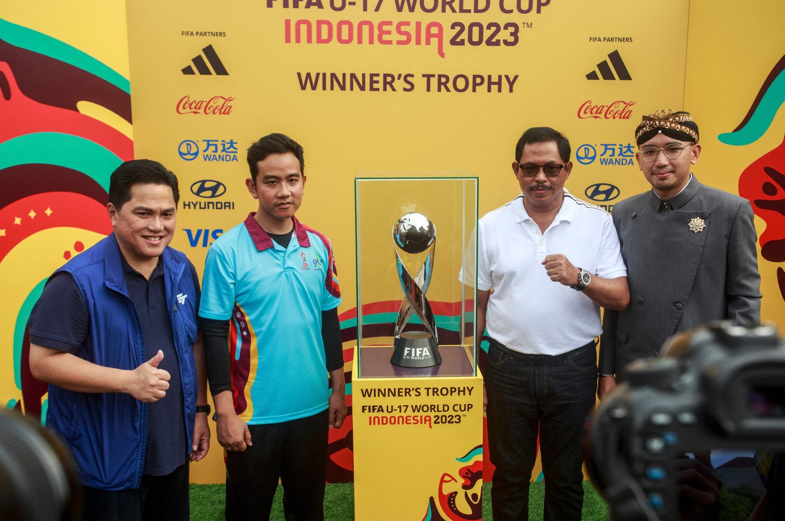 The Solo Mayor Gibran Rakabuming Raka (2nd L), a vice presidential candidate and Indonesian President Joko Widodo&#039;s son, and Indonesian Football Association&#039;s Chairperson Erick Thohir (L) pose next to the FIFA U-17 World Cup trophy during a promotional event for the upcoming youth football tournament, Solo, Indonesia, Nov. 5, 2023. (AFP Photo)