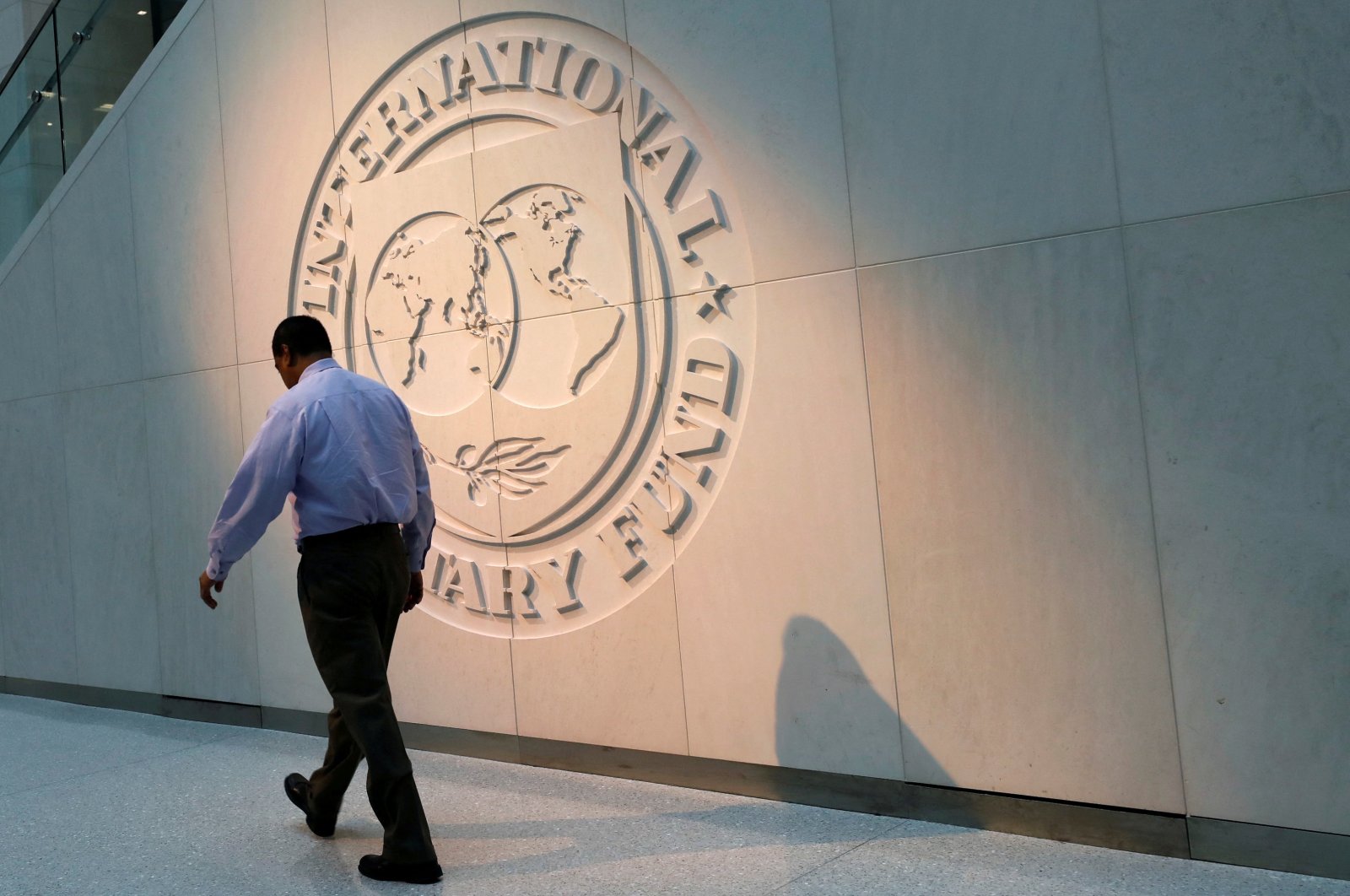 A man walks past the International Monetary Fund (IMF) logo at its headquarters in Washington, U.S., May 10, 2018. (Reuters Photo) 