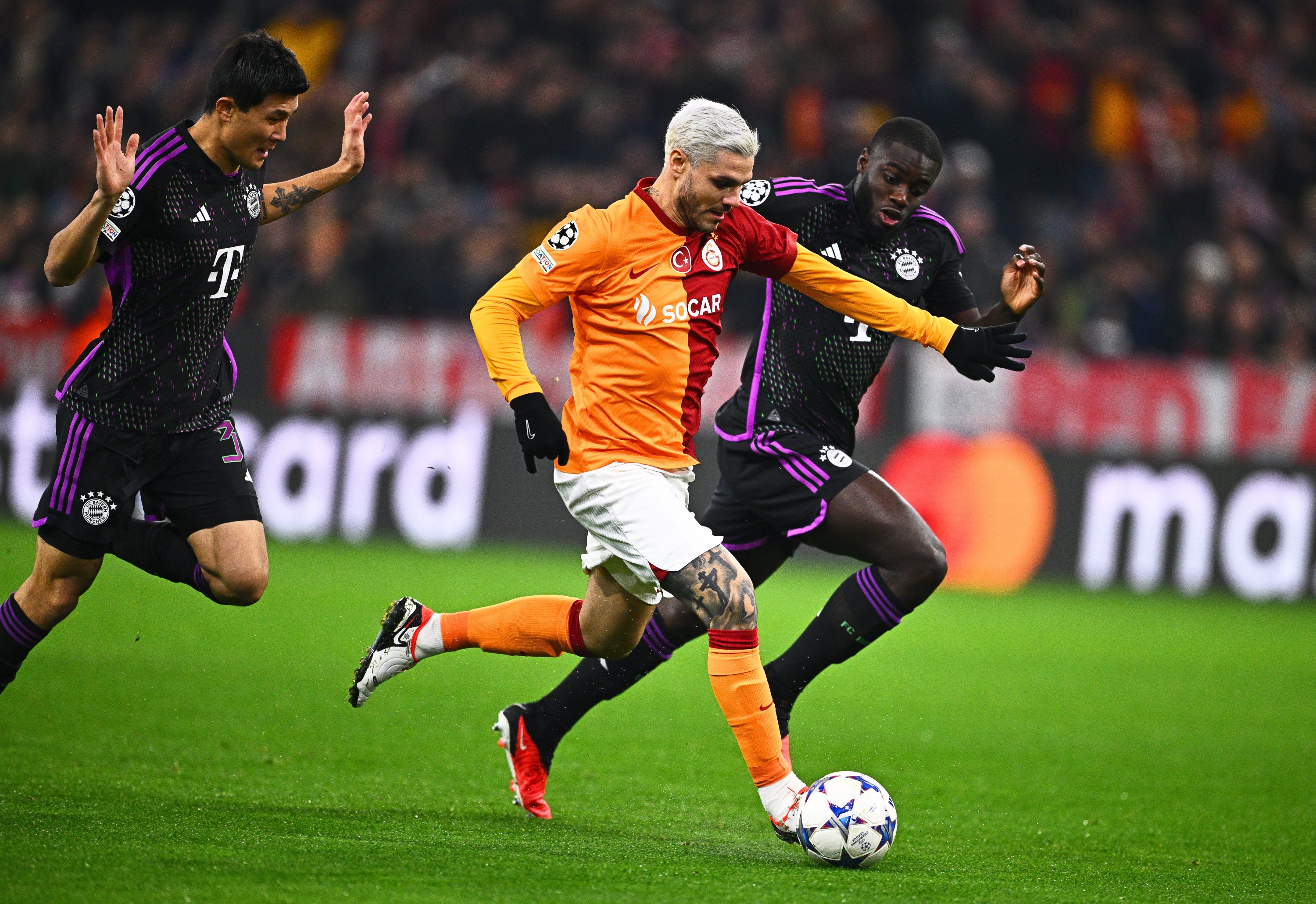 Galatasaray's Mauro Icardi (M) in action against Bayern Munich's players Min-Jae Kim (L) and Dayot Upamecano during the Champions League match at the Allianz Arena, Nov. 8, 2023. (Getty Images Photo)