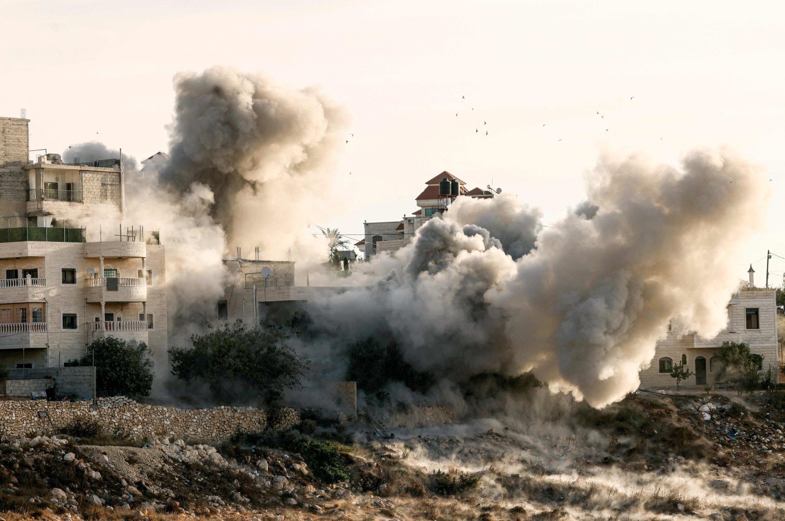 Smoke billows as two Palestinian homes are blown up by Israel. At least 170 Palestinians and three Israelis have been killed in the occupied West Bank since Oct. 7, Hebron, Palestine, Nov. 10, 2023. (AFP Photo).