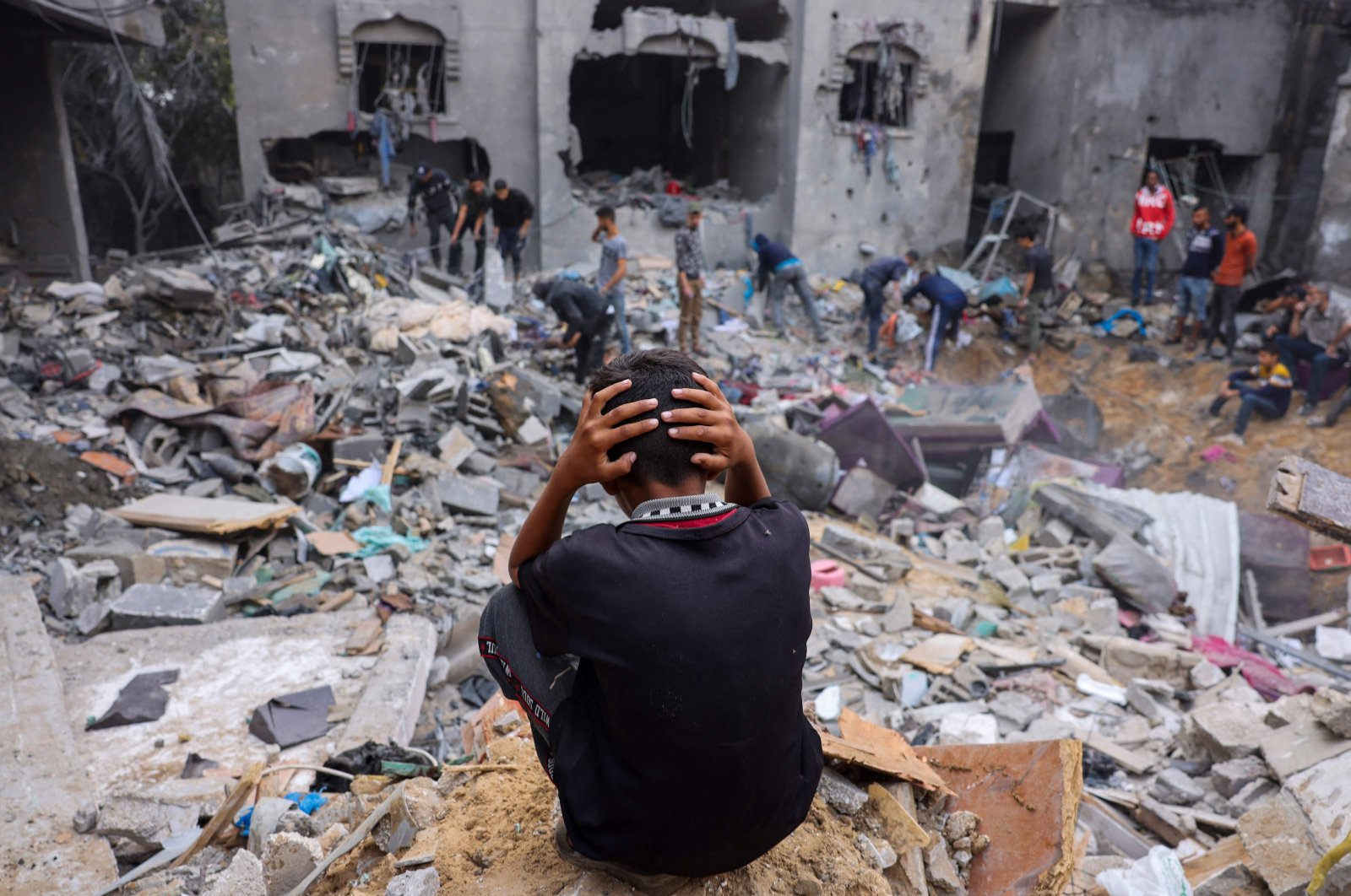 A child reacts as people salvage belongings amid rubble of a damaged building following Israeli strikes on Rafah in the southern Gaza Strip, Palestine, Nov. 12, 2023. (AFP Photo)