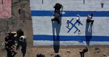An aerial view shows activists painting a mural denouncing Israel&#039;s attacks on Gaza, next to the Rio Grande in Ciudad Juarez, Chihuahua state, Mexico, Nov. 12, 2023. (EPA Photo)
