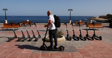 A man rides a rental e-scooter after the government announced that all rental e-scooters will be banned from March 2024, Sliema, Malta, Oct. 20, 2023. (Reuters Photo)