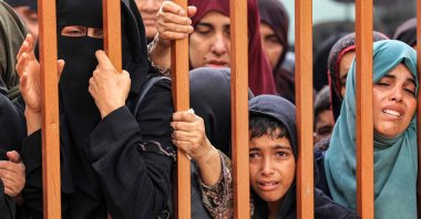 People mourn as they stand behind a metal fence near the bodies of victims who were killed in Israeli bombardment before their burial, outside the morgue at Nasser hospital in Khan Yunis in the southern Gaza Strip, Palestine, Nov. 14, 2023. (AFP Photo)