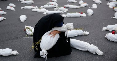 A woman takes part in an installation featuring mock shrouded bodies of children in Palestine square in support of Palestinians, Tehran, Iran, Nov. 13, 2023. (AFP Photo)