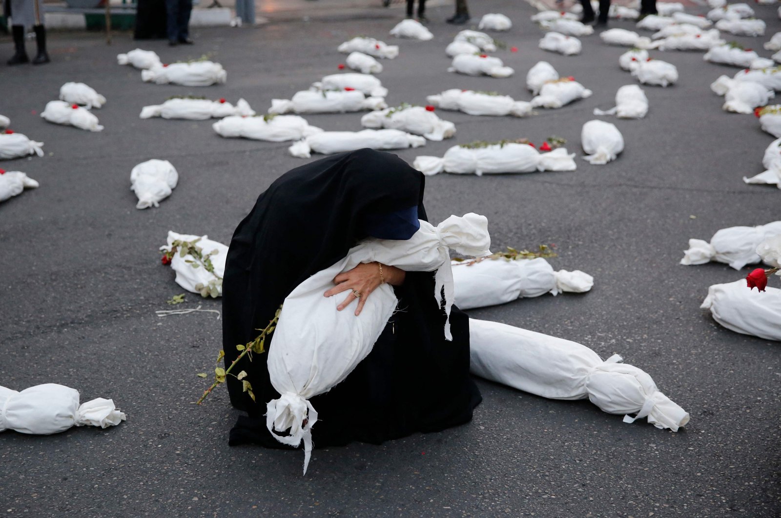 A woman takes part in an installation featuring mock shrouded bodies of children in Palestine square in support of Palestinians, Tehran, Iran, Nov. 13, 2023. (AFP Photo)