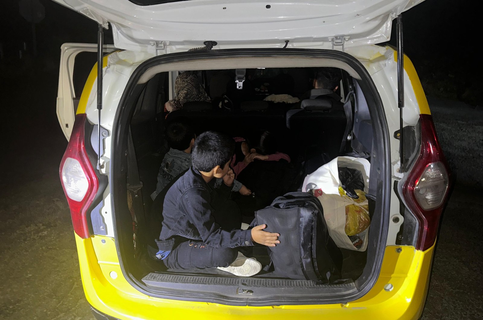 Irregular migrants from Afghanistan sit inside a taxi stopped by Turkish security forces, Çanakkale, western Türkiye, Nov. 7, 2023. (AA Photo)