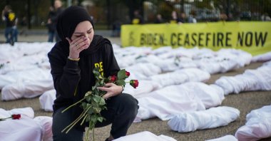 An activist wipes her eye while placing flowers on white-shrouded body bags representing victims in the Israeli-Palestinian conflict, in front of the White House, Washington, D.C., U.S., Nov. 15, 2023. (AFP Photo)