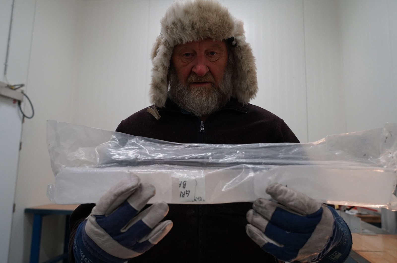 Joergen Peder Steffensen, professor of ice core-related research at the Niels Bohr Institute, University of Copenhagen, holds part of an ice core sample in the University of Copenhagen’s ice core repository in Copenhagen, Denmark, Oct. 26, 2023. (AFP Photo)