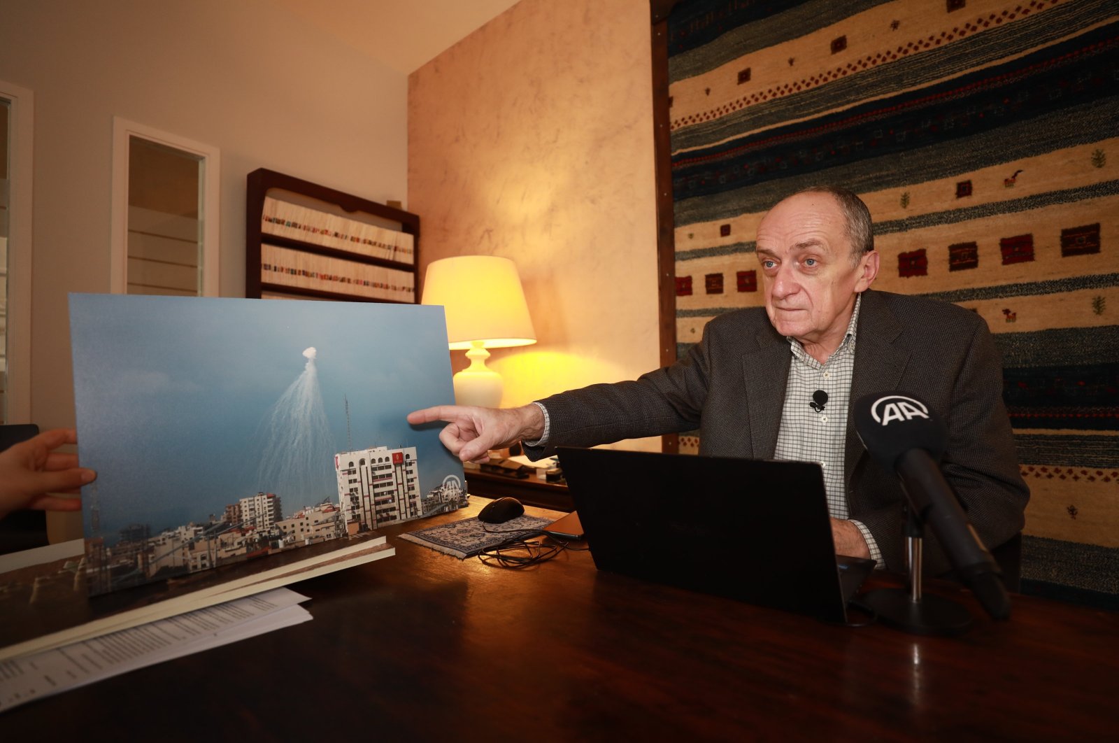 French lawyer Gilles Devers with a photo documenting Israel&#039;s use of the outlawed white phosphorus chemical weapon on the Gaza Strip, Paris, France, Nov. 16, 2023. (AA Photo)