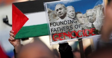 A demonstrator holds a placard depicting Israeli Prime Minister Benjamin Netanyahu (L), U.S. President Joe Biden (C), French President Emmanuel Macron (C-2) and Israeli Defense Minister Yoav Gallant (R) during a protest in support of Palestinians in Gaza, Brussels, Belgium, Nov. 11, 2023. (Reuters Photo)