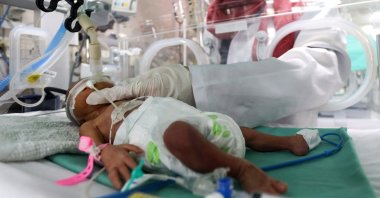 A medical worker assists a premature Palestinian baby who lies in an incubator at the maternity ward of Shifa Hospital, which according to health officials is about to shut down as it runs out of fuel and power, as the conflict between Israel and the Palestinian Islamist group Hamas continues, Gaza City, Palestine, Oct. 22, 2023. (Reuters Photo)