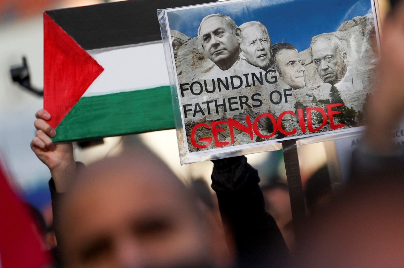 A demonstrator holds a placard depicting Israeli Prime Minister Benjamin Netanyahu (L), U.S. President Joe Biden (C), French President Emmanuel Macron (C-2) and Israeli Defense Minister Yoav Gallant (R) during a protest in support of Palestinians in Gaza, Brussels, Belgium, Nov. 11, 2023. (Reuters Photo)