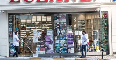 A pharmacy staff disinfects out of the pharmacy during a two-day curfew which was imposed to prevent the spread of the coronavirus disease, in Istanbul, Türkiye, April 11, 2020. (Getty Images)