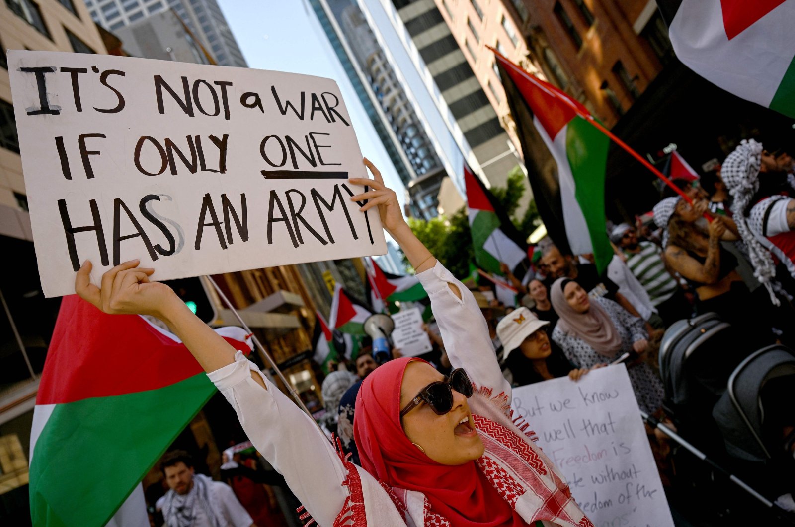 People march with flags and placards during a rally in support of the Palestinian people in Sydney, Australia, Nov. 19, 2023. (AFP Photo)