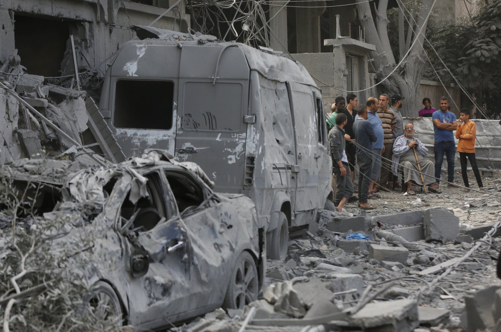 People look at destroyed buildings and cars in the Nuseirat Camp amid Israeli attacks, Gaza Strip, Palestine, Nov. 18, 2023. (AA Photo)