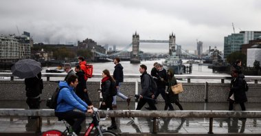 Pedestrians walk over the London Bridge with Tower Bridge in the background, London, United Kingdom, Nov. 2, 2023. (AFP Photo)