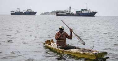 A fisherman paddles in front of commercial fishing boats in the Hann Bay in Dakar, Senegal, Sept. 27, 2023. (AFP Photo)