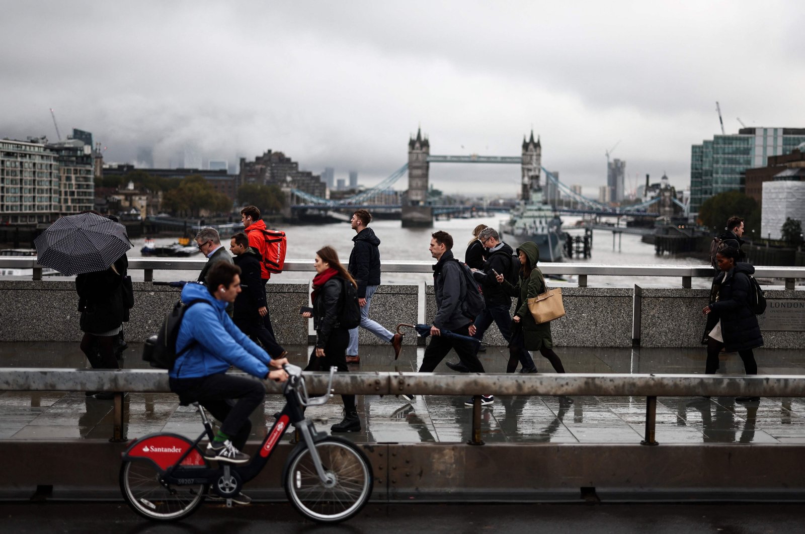 Pedestrians walk over the London Bridge with Tower Bridge in the background, London, United Kingdom, Nov. 2, 2023. (AFP Photo)