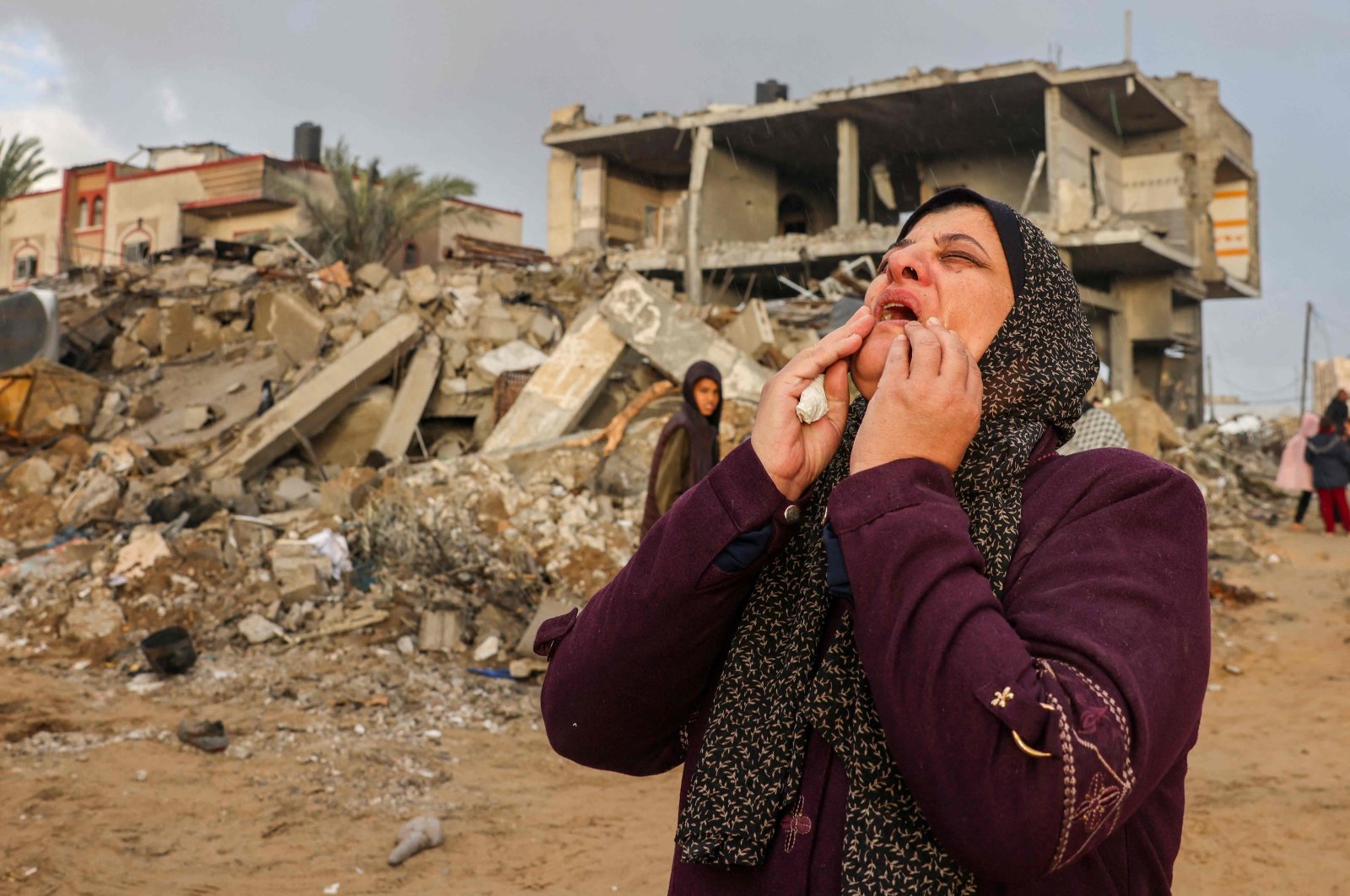 A Palestinian woman reacts as people inspect the damage following Israeli strikes on Rafah, on the southern Gaza Strip, on November 20, 2023, amid continuing battles between Israel and the militant group Hamas. (Photo by Mohammed ABED / AFP)