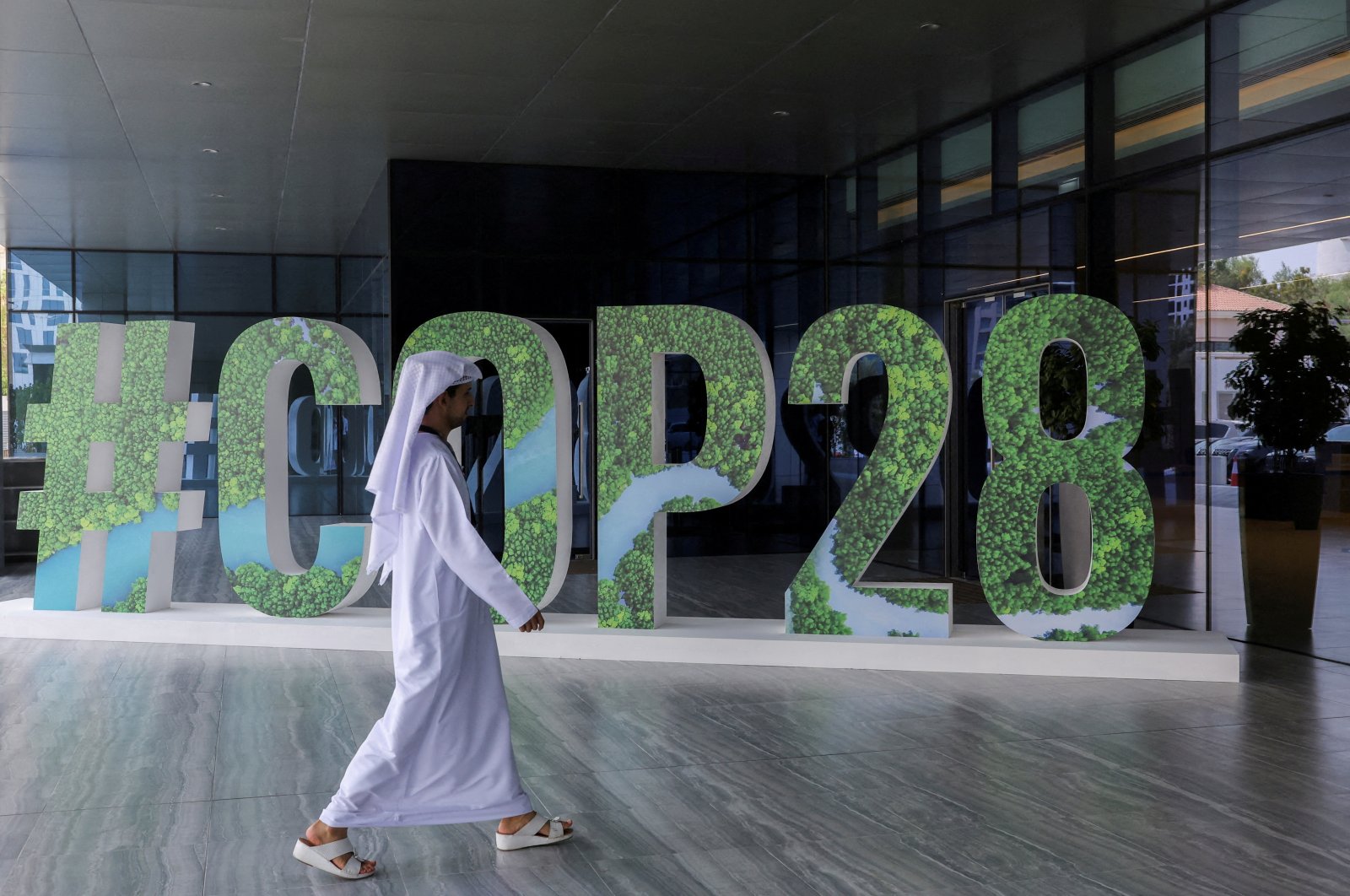 A person walks past a &quot;#COP28&quot; sign during The Changemaker Majlis, a one-day CEO-level thought leadership workshop focused on climate action, in Abu Dhabi, United Arab Emirates, Oct. 1, 2023. (Reuters Photo)