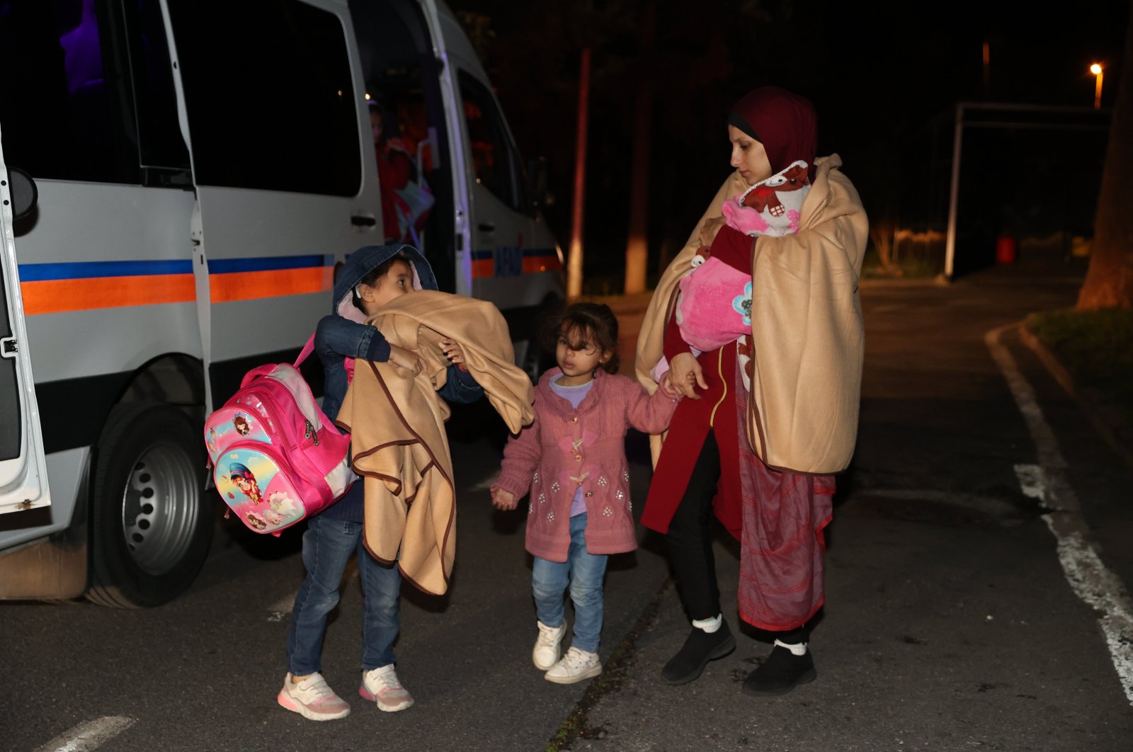 A family evacuated from Gaza walks toward a guest house near the airport where they will be temporarily accommodated, in Istanbul, Türkiye, Nov. 20, 2023. (AA Photo)