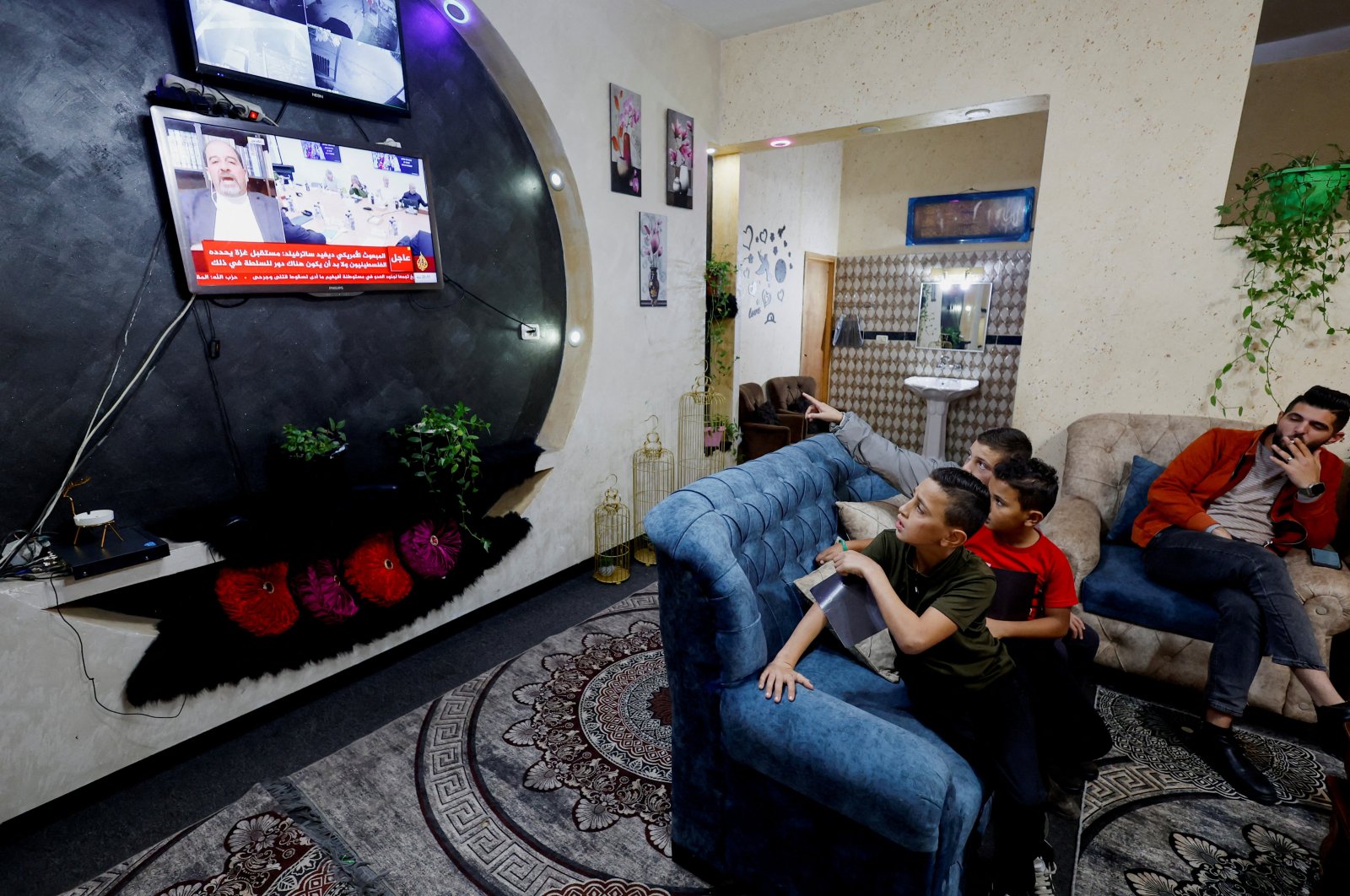 A family of young Palestinian prisoners watches news updates on the Israeli hostages and Palestinian prisoners swap deal, near Hebron, Israeli-occupied West Bank, Palestine, Nov. 21, 2023.