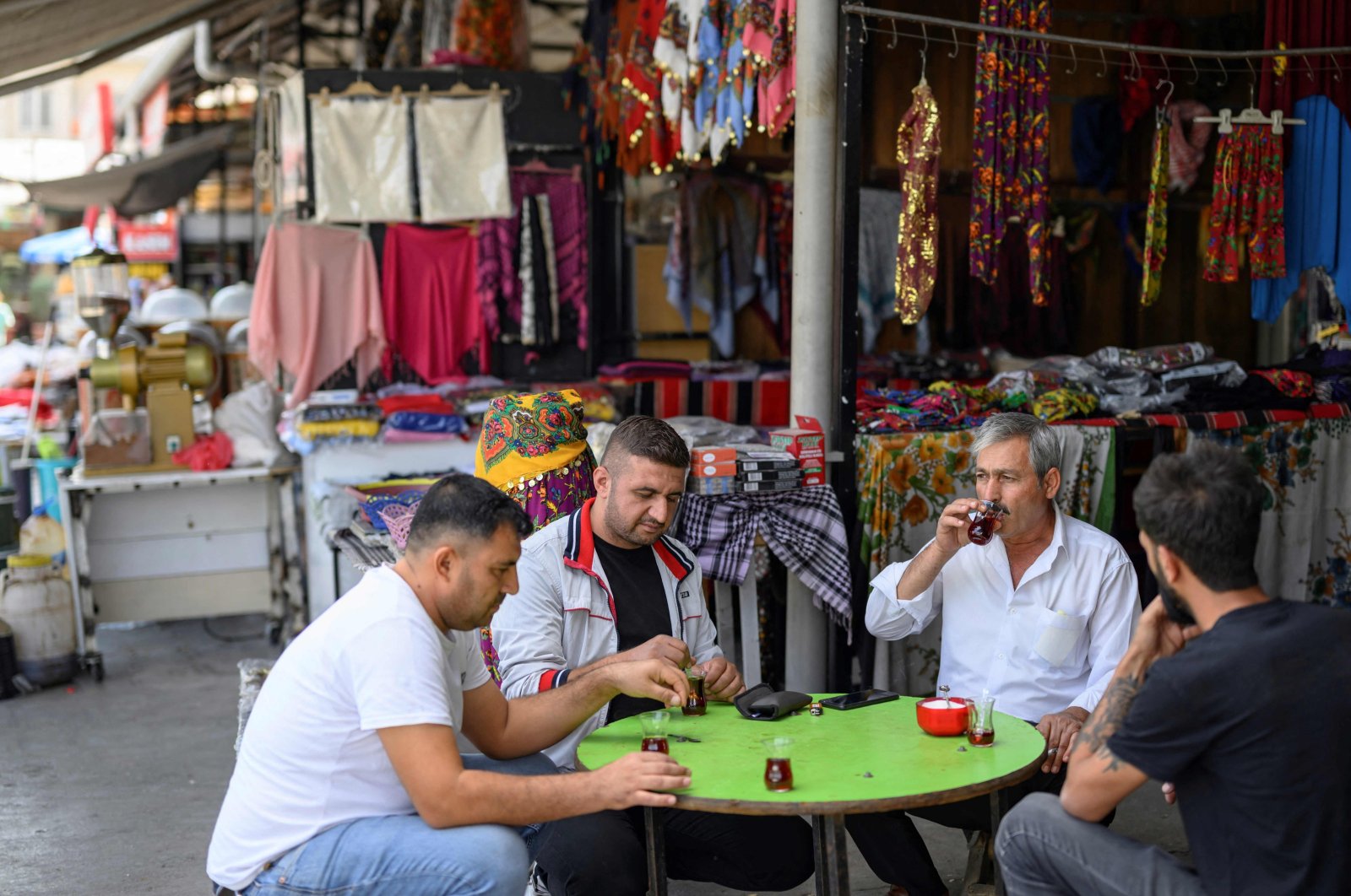 People sit at the market in the bazaar near Balıklıgöl, in Şanliurfa, southeastern Türkiye, Oct. 18, 2023. (AFP Photo)