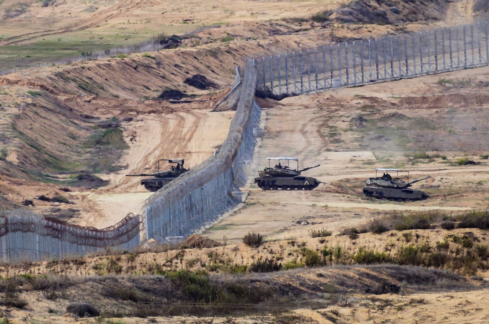 Israeli army tanks exiting the security barrier surrounding the Palestinian territory, Nov. 22, 2023. (AFP Photo)