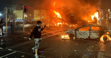 Flames rise from a car and a bus, set alight at the junction of Bachelors Walk and the O&#039;Connell Bridge, Dublin, Ireland, Nov. 23, 2023. (AFP Photo)