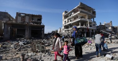 Displaced Palestinians return to their homes as they walk near houses destroyed in an Israeli strike during the conflict, amid the temporary truce between Hamas and Israel, in Khan Younis in the southern Gaza Strip, Nov. 24, 2023. (Reuters Photo)