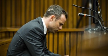 South African paralympic athlete Oscar Pistorius sits on the fifth day of his trial for the 2013 murder of his girlfriend, Pretoria, South Africa, March 7, 2014. (AFP Photo)