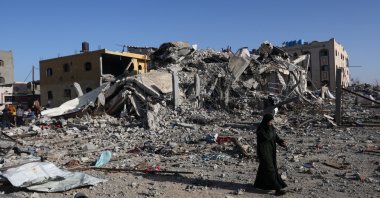 A Palestinian woman walks near a house destroyed in an Israeli strike in Khan Younis, southern Gaza Strip, Palestine, Nov. 24, 2023. (Reuters Photo)